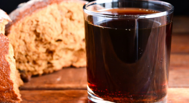 loaf of bread next to a glass of dark beer