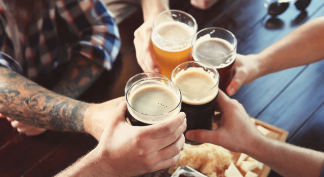 A group of people performing a toast with beer